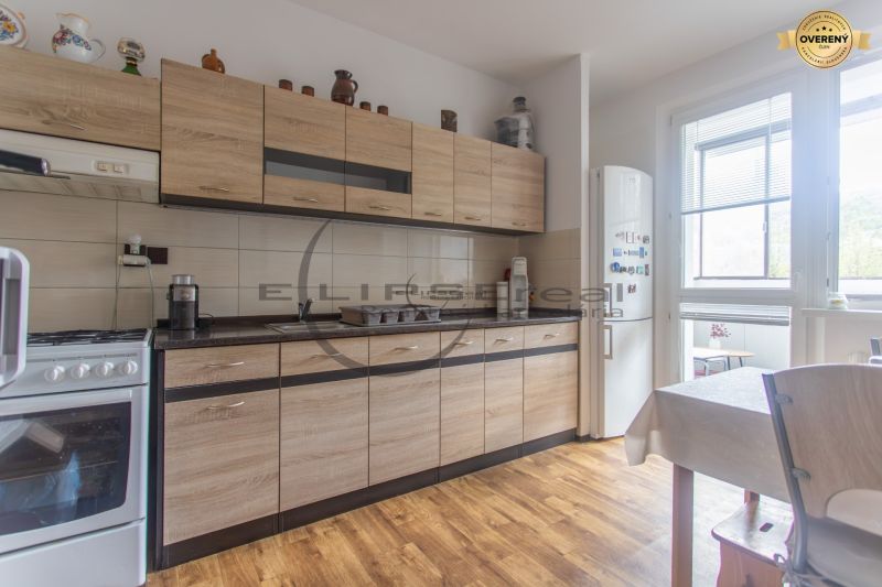 A kitchen with a wooden decor floor and furniture in a 3-room apartment.