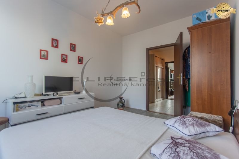 Bedroom in a 3-room apartment with a TV, frames on the wall, and wooden cabinet furniture.