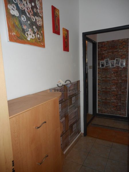 Interior of a 2-room apartment with decorative paintings on the wall and tiles on the floor.
