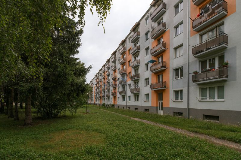 An apartment building on 28. októbra Street in Trenčín surrounded by greenery.