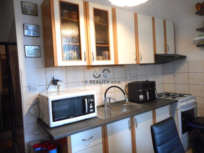 Kitchen in a 2-room apartment with a kitchen unit, stove, and microwave oven.