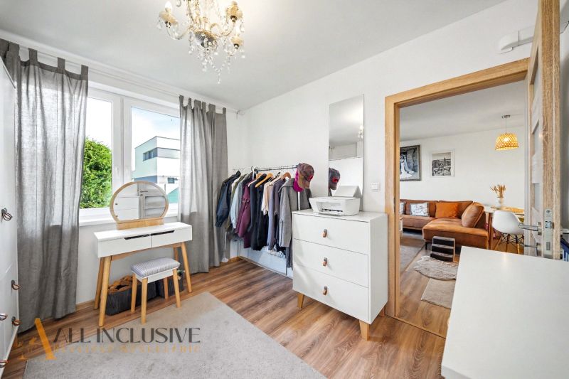 A room in a family house with a dressing table, wardrobe, and a floor with a wooden decor.