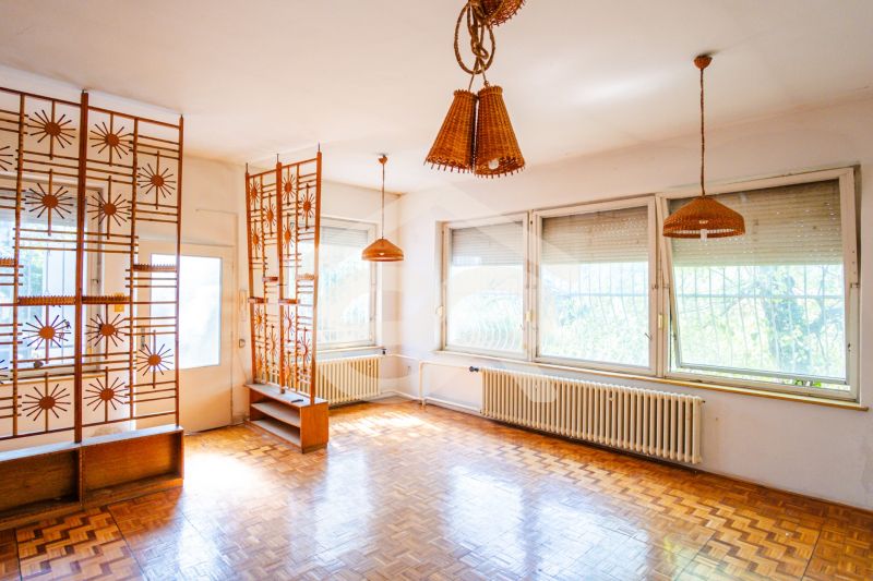 Interior of a family house with wooden decor, an original partition wall, and wicker lights.