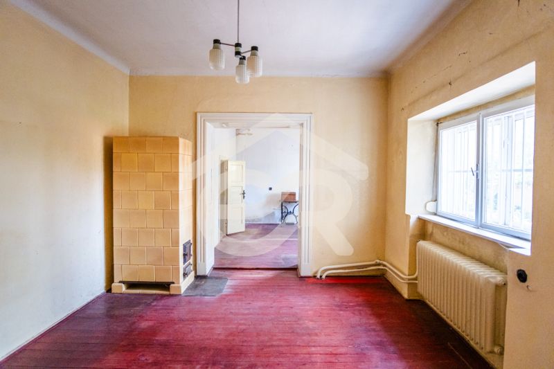 Interior of a family house with a tiled stove and a wooden decor floor.
