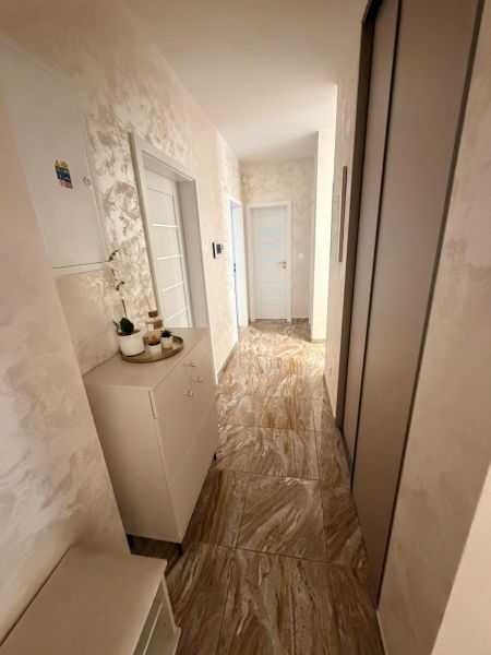 Interior of a 3-room apartment with tiles and cabinets in the hallway.