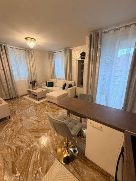 A living room in a three-room apartment with tiles and a light sofa, accessories in turquoise.