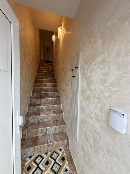 A narrow staircase space in a 3-room apartment with a patterned carpet.