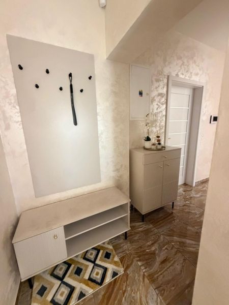 Interior with a coat rack, cabinet, and tiled floor in a 3-room apartment.