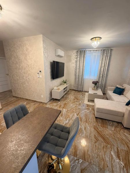 Living room in a 3-room apartment with glossy tiles and comfortable seating.