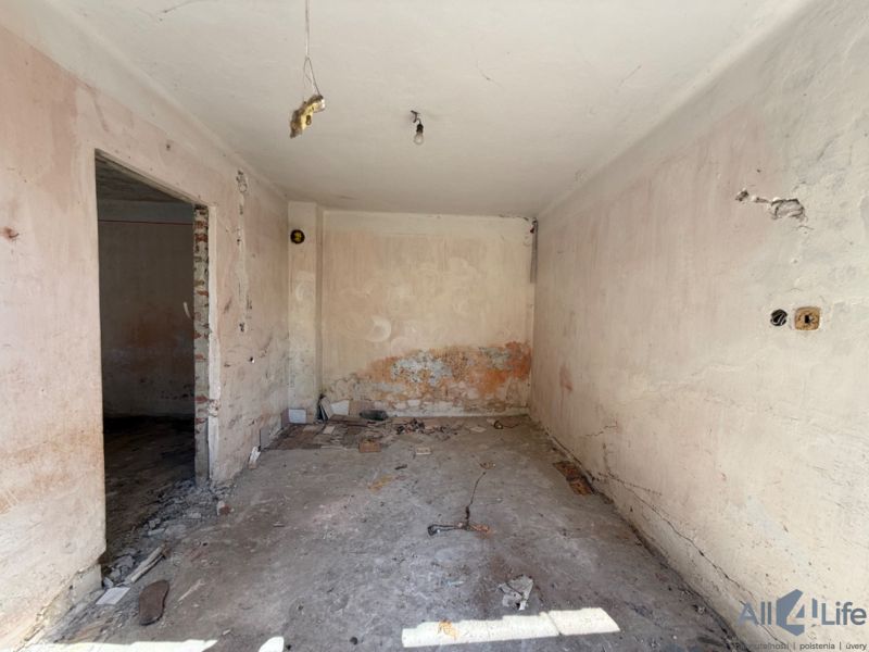 A room in a family house before renovation with exposed walls and floor.