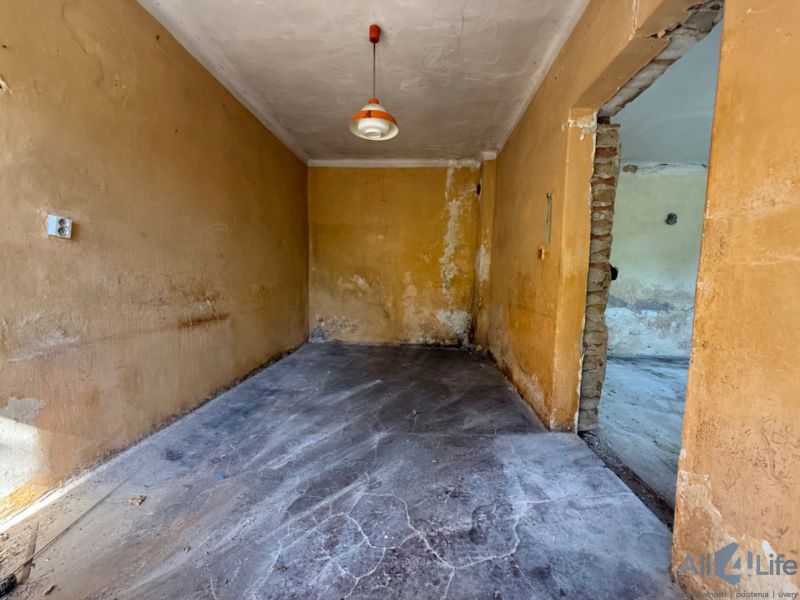 A room in a family house with a concrete floor and orange walls.