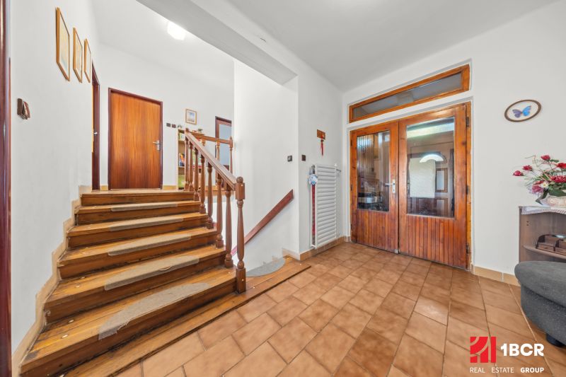 Interior of a family house with a staircase, tiles, and wall decorations.