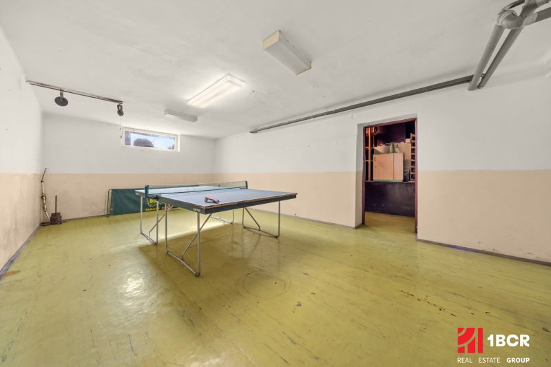 A ping pong table in a family house on a floor with a wooden decor.