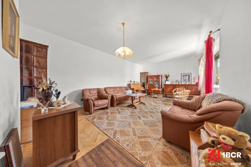 Living room in a family house with a wooden decor floor, comfortable leather sofas.