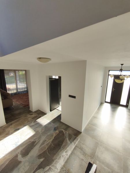 Interior of a family house with large tiles and entrance doors.