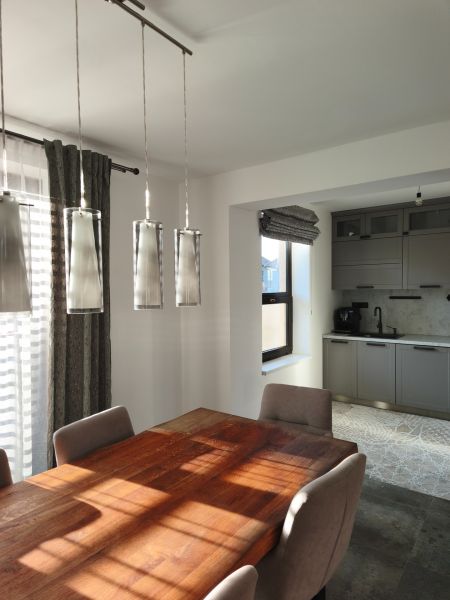 Dining table with wood decor and gray cabinets in a family house.