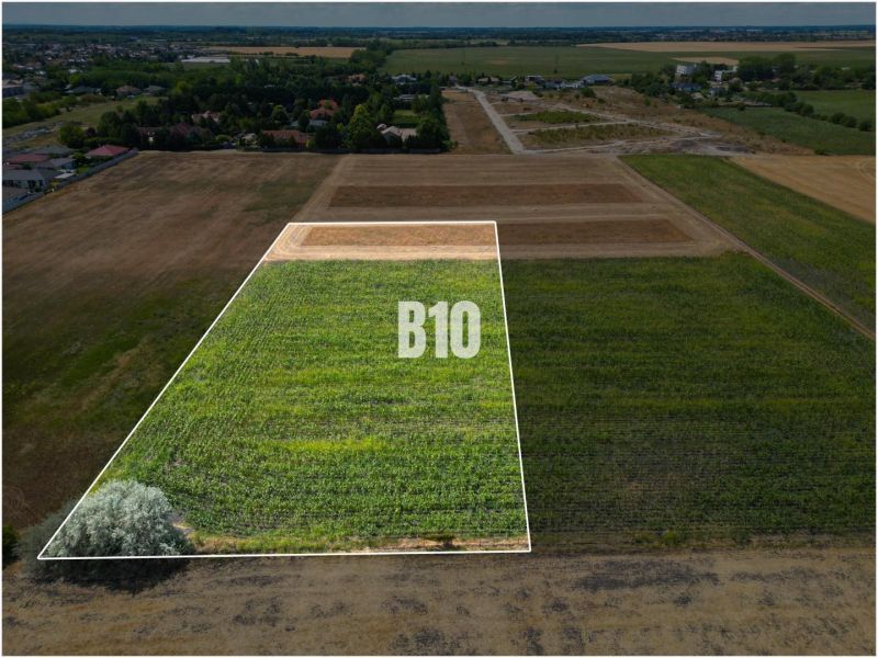 A plot for living in Nové Zámky, bordered by greenery and the surrounding countryside.