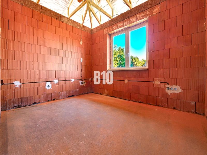 Interior of a family house in Čeľadice with brick walls and a fitted window.