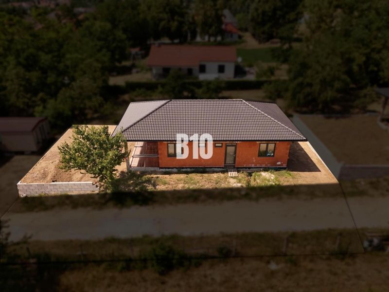 A family house in Čeľadice with a brick facade, a sloped roof, and fencing.