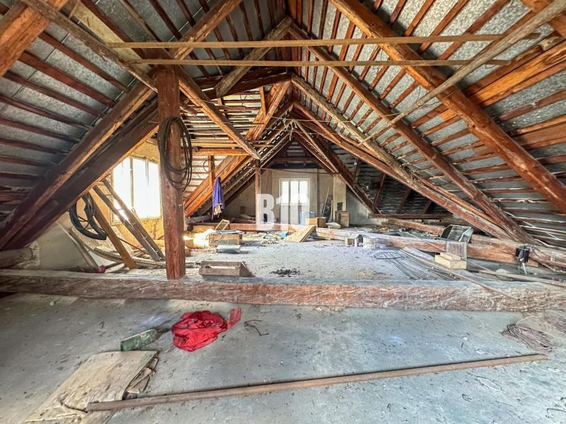 The attic of a family house in Púchov with wooden beams and clutter.