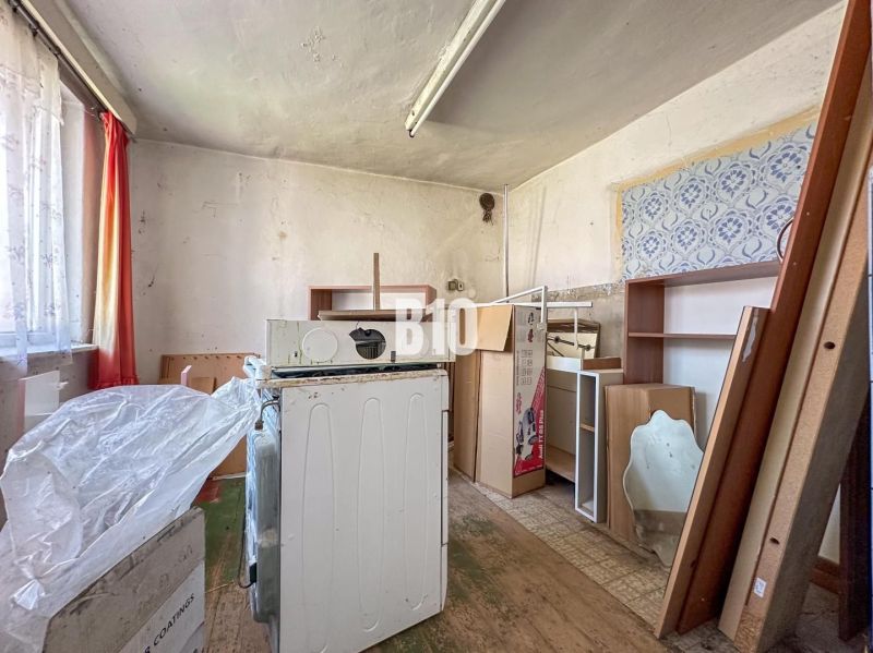 Room in a family house with stored furniture and an old washing machine.