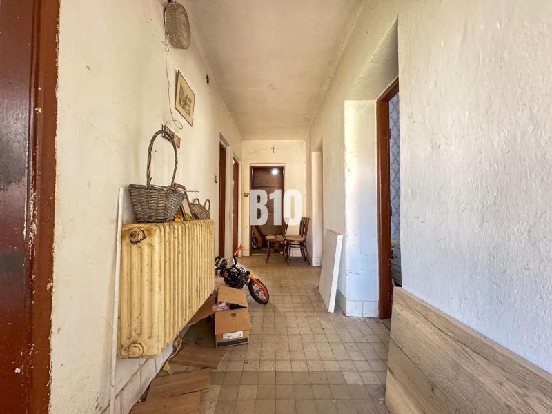 A narrow hallway in a family house with retro decorations and an older radiator.