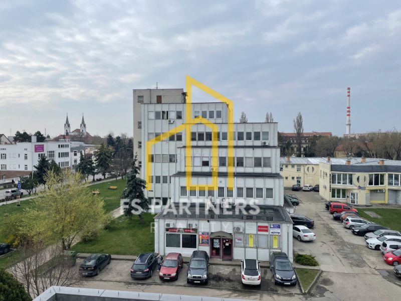 Office building on Záhradnícka Street in Komárno with parking and greenery.