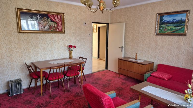 Living room with floral decor in a family house, red armchairs, patterned carpet.