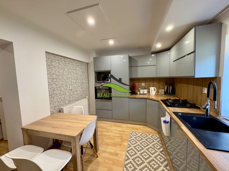 A kitchen in a family house with a modern kitchen unit and a floor with a wooden decor.