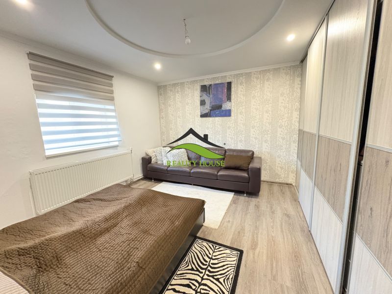 Living room in a family house with a wood-decor floor and a sofa.