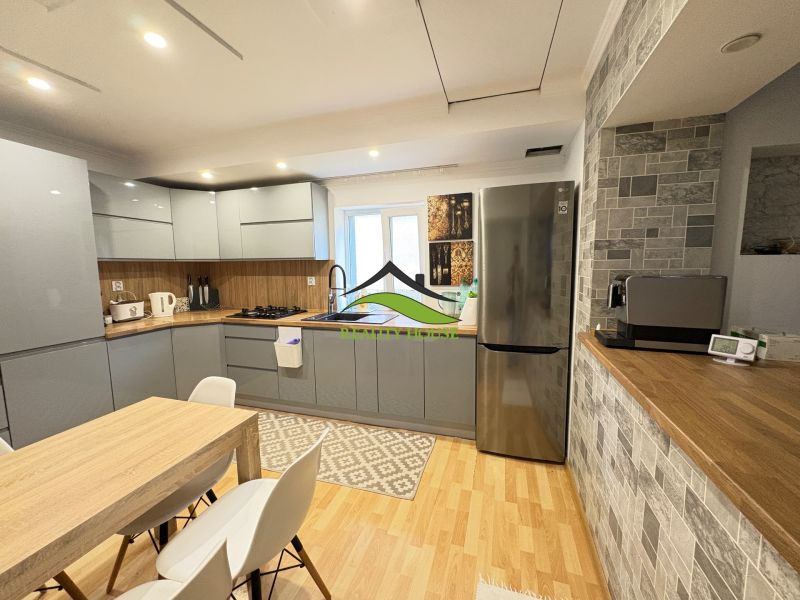 A kitchen in a family house with a wooden decor floor, equipped with modern appliances.