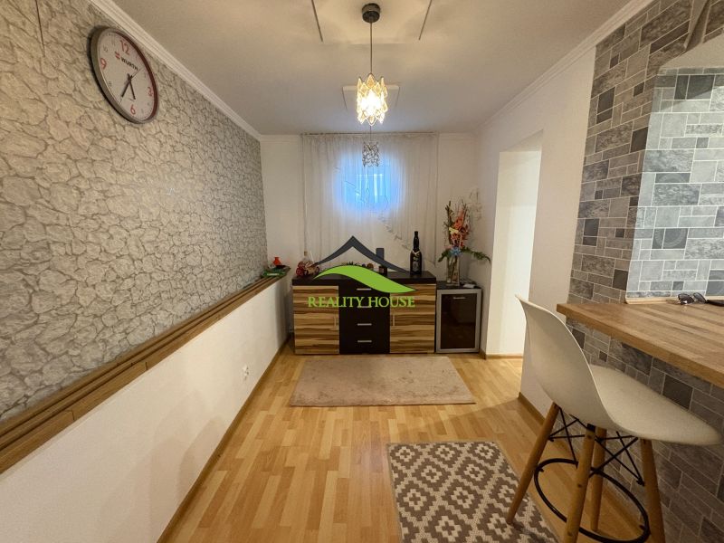 Interior of a family house with a wall featuring a stone design and a floor with a wood design.