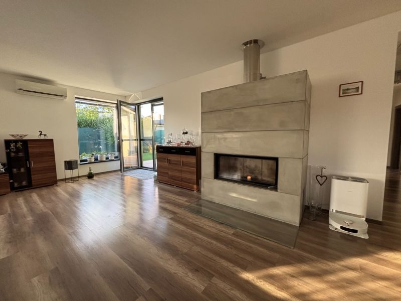 Living room in a family house with a fireplace and a wooden decor floor.