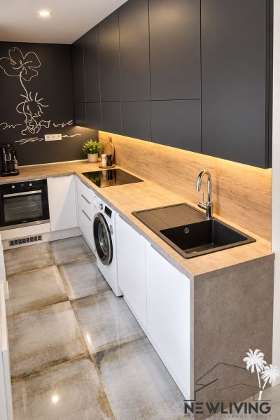A kitchen with appliances and a wooden decor floor in a 3-room apartment.