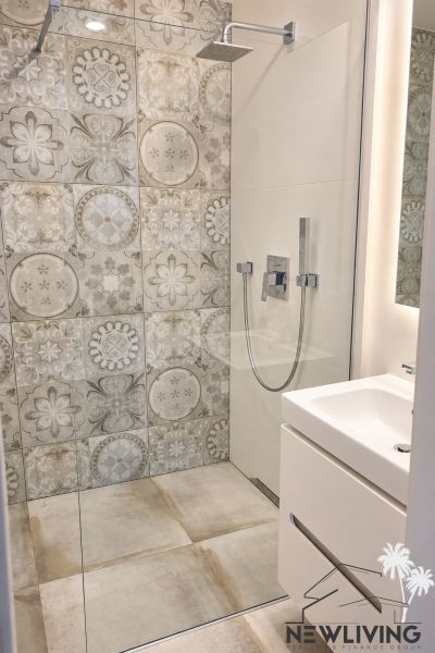 A shower corner with decorative tiles in the bathroom of a 3-room apartment.