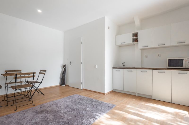 Interior with a kitchen unit, white walls, and a floor with a wooden decor on recreational grounds.