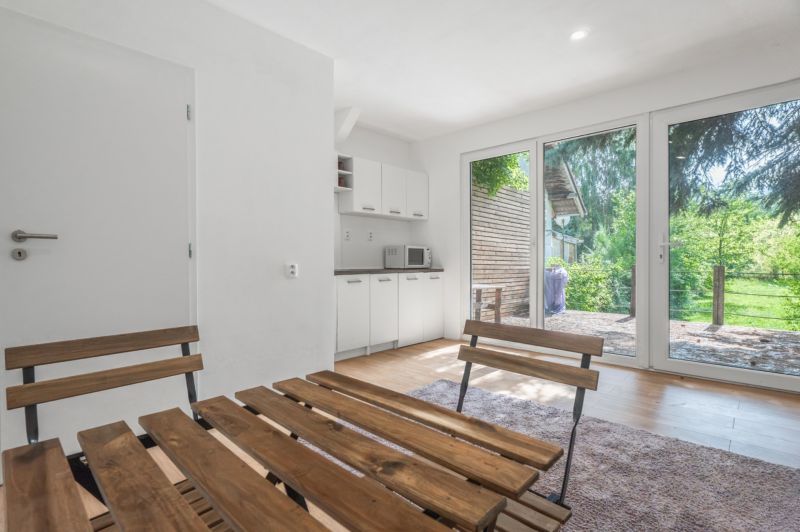 A bright room with wooden furniture and a kitchen, recreational grounds.
