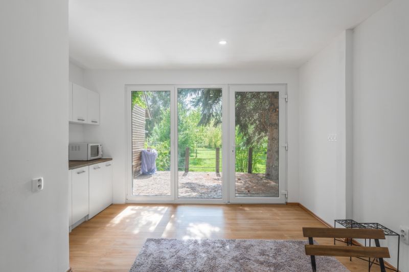 Interior with large windows, kitchen unit, and wooden decor flooring. Recreational plots.