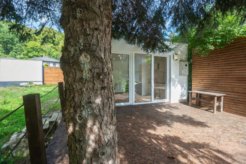 A terrace by the house on Recreational Land in Bratislava - Devín surrounded by greenery and trees.