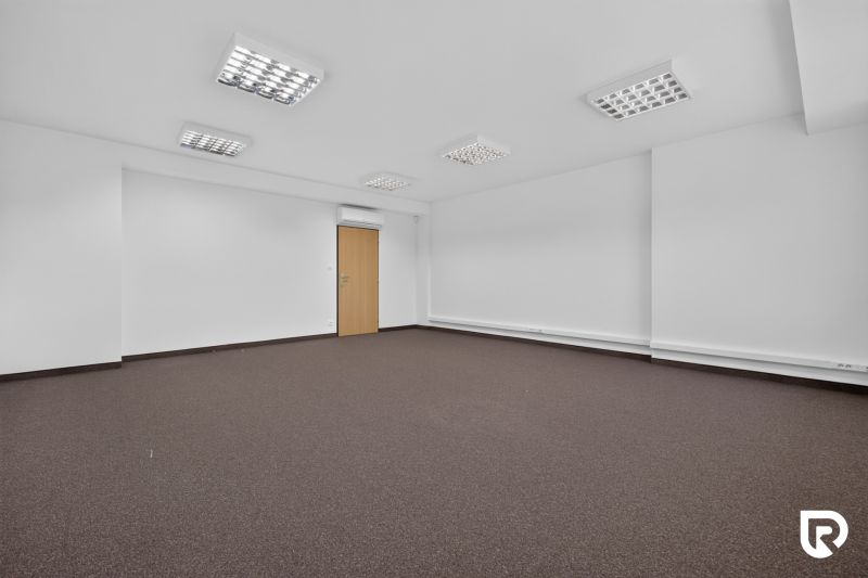 Spacious office spaces with carpet and white walls.