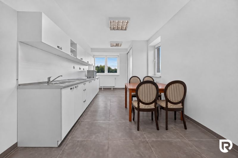 Offices with a kitchenette and dining seating, floor with dark decor.