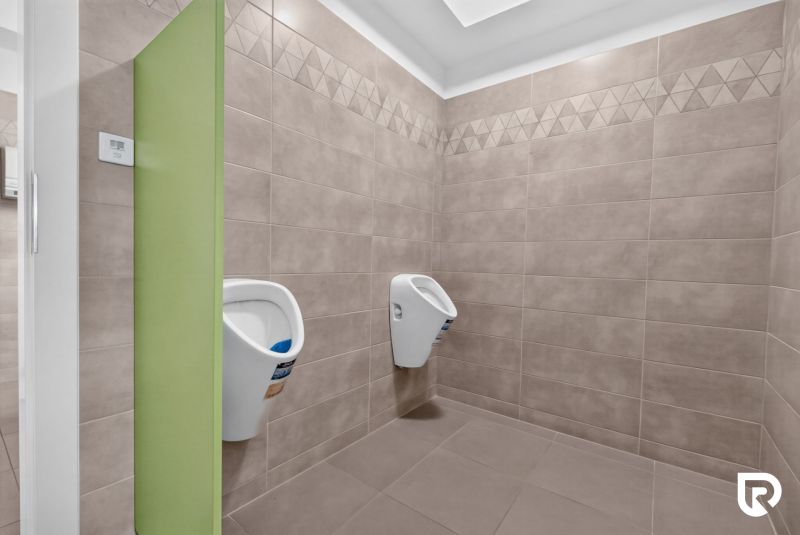Interior of an office with wall paneling and two urinals.