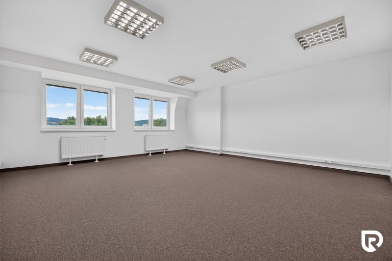Spacious offices with windows and white walls, suitable for a work environment.