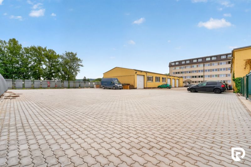Parking lot and yellow building on Brnianska Street in Trenčín, suitable for offices.