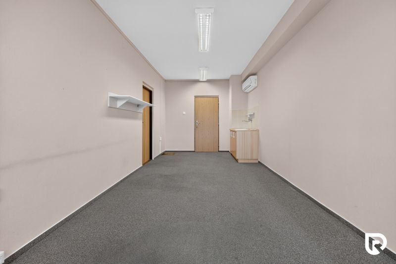 Offices with carpet and a small kitchenette, a simple space for work or meetings.