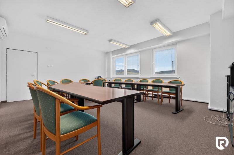 Meeting room with a long table and chairs, simple lighting, offices.