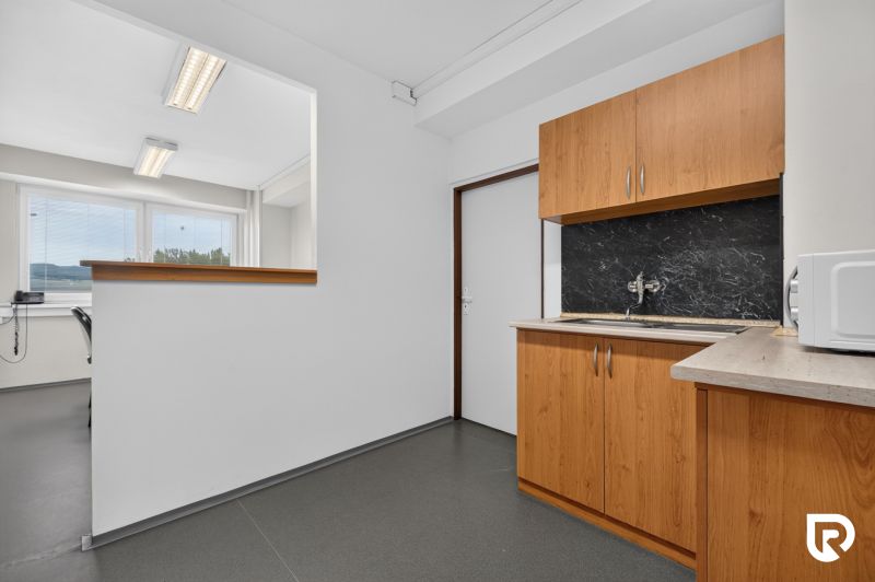 Offices with gray flooring, wooden cabinet decor, and a window for natural light.