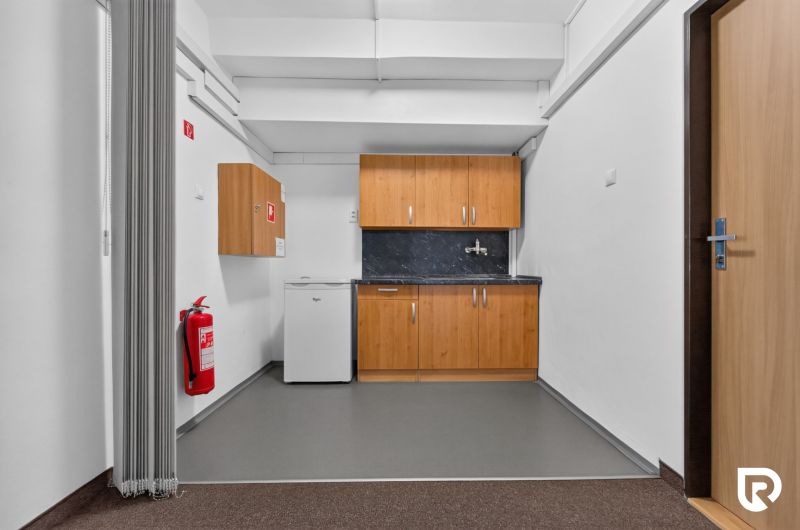 Offices with white walls, a kitchenette, and fire equipment.