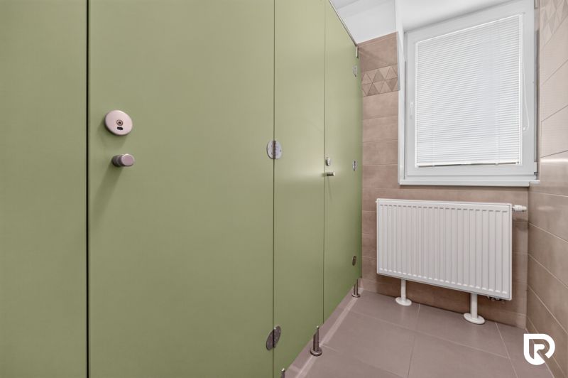Green doors in offices, radiator and window with a blind.