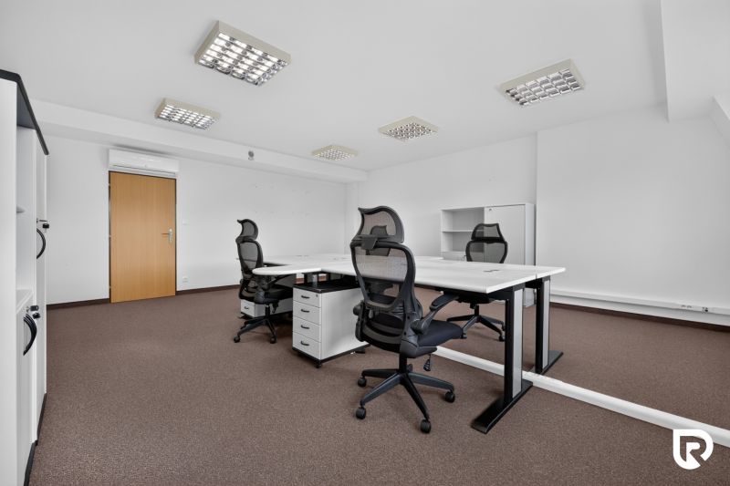 Offices with white desks and black chairs.